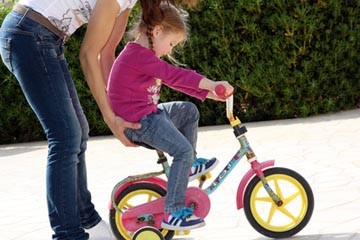 Mutter bringt Kind Fahrradfahren bei