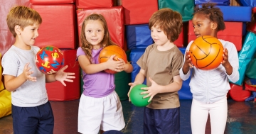 Kinder spielen mit Bällen